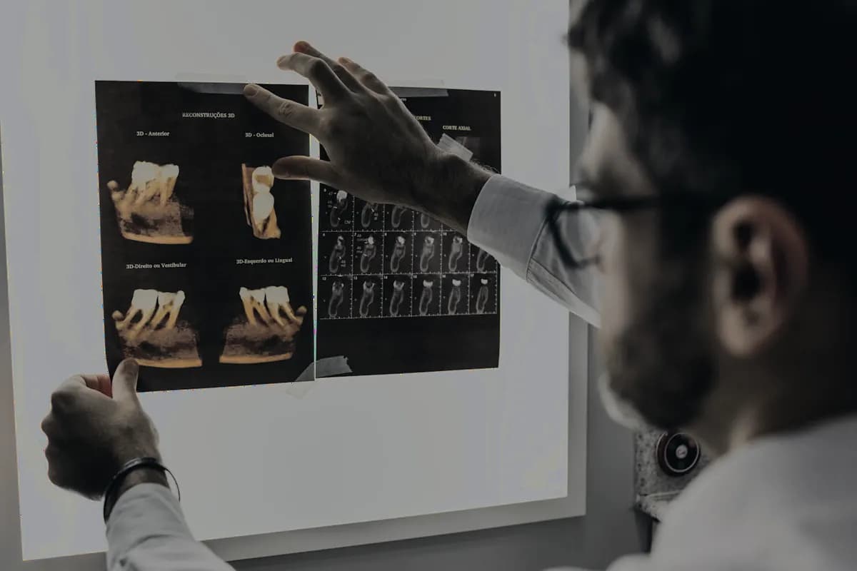 Un odontólogo revisando radiografías en un negatoscopio.